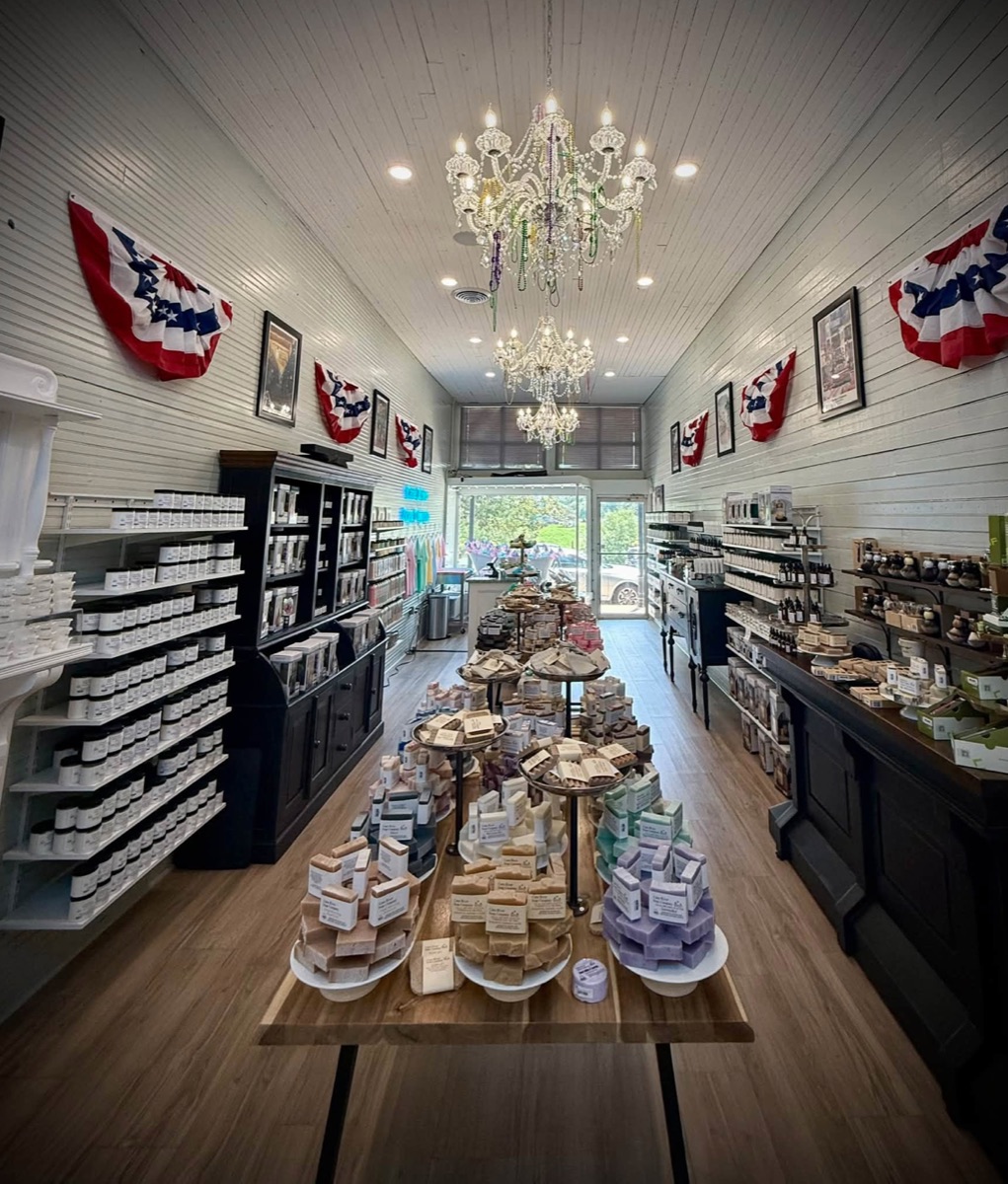 Inside the Cane River Soap Company shop on Front Street, showing shelves of soap and skincare products under chandeliers